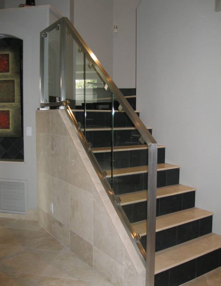A staircase with a stainless steel railing and a glass railing