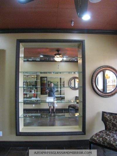 A man is standing in front of a large mirror in a living room