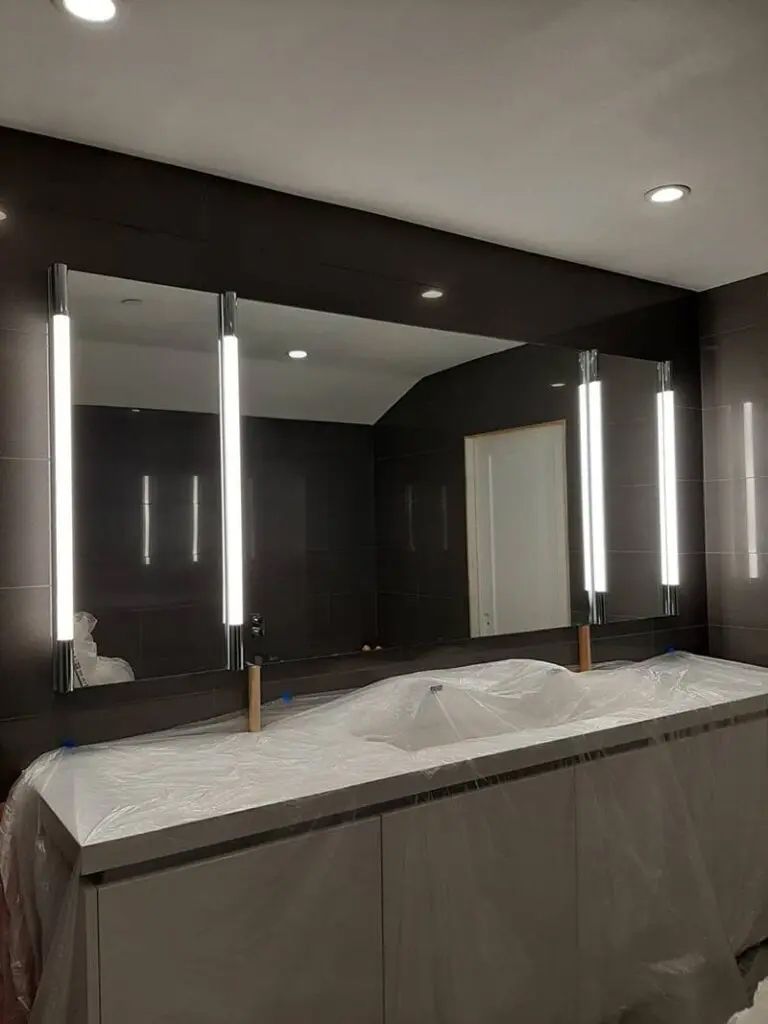 A bathroom with two sinks and a large mirror