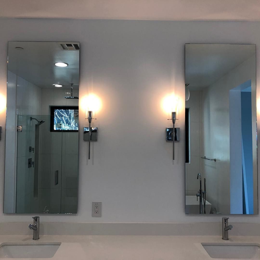 A bathroom with two sinks and two mirrors.