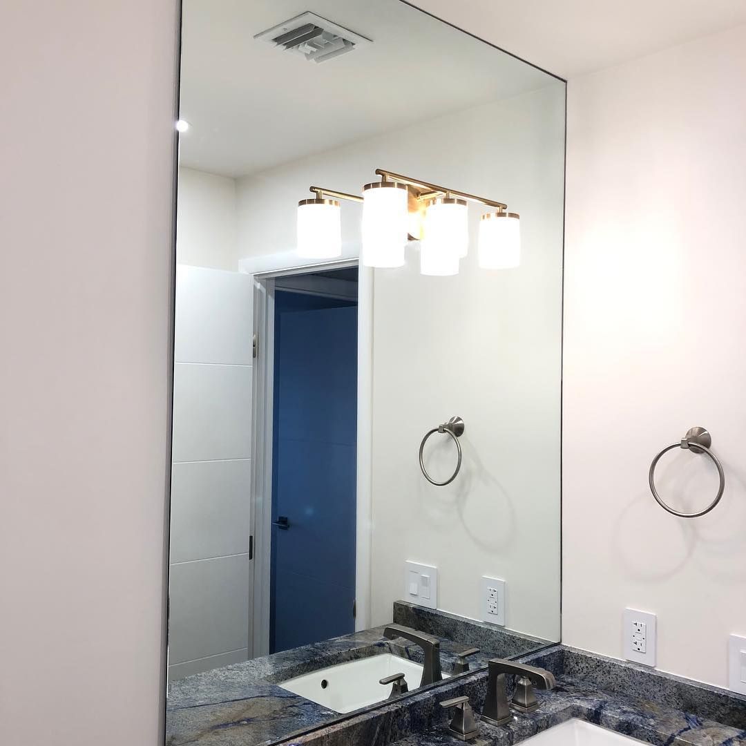 A bathroom with a large mirror and a sink