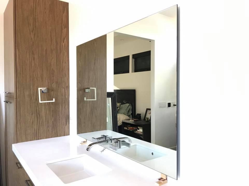 A bathroom with a sink, mirror and cabinets.