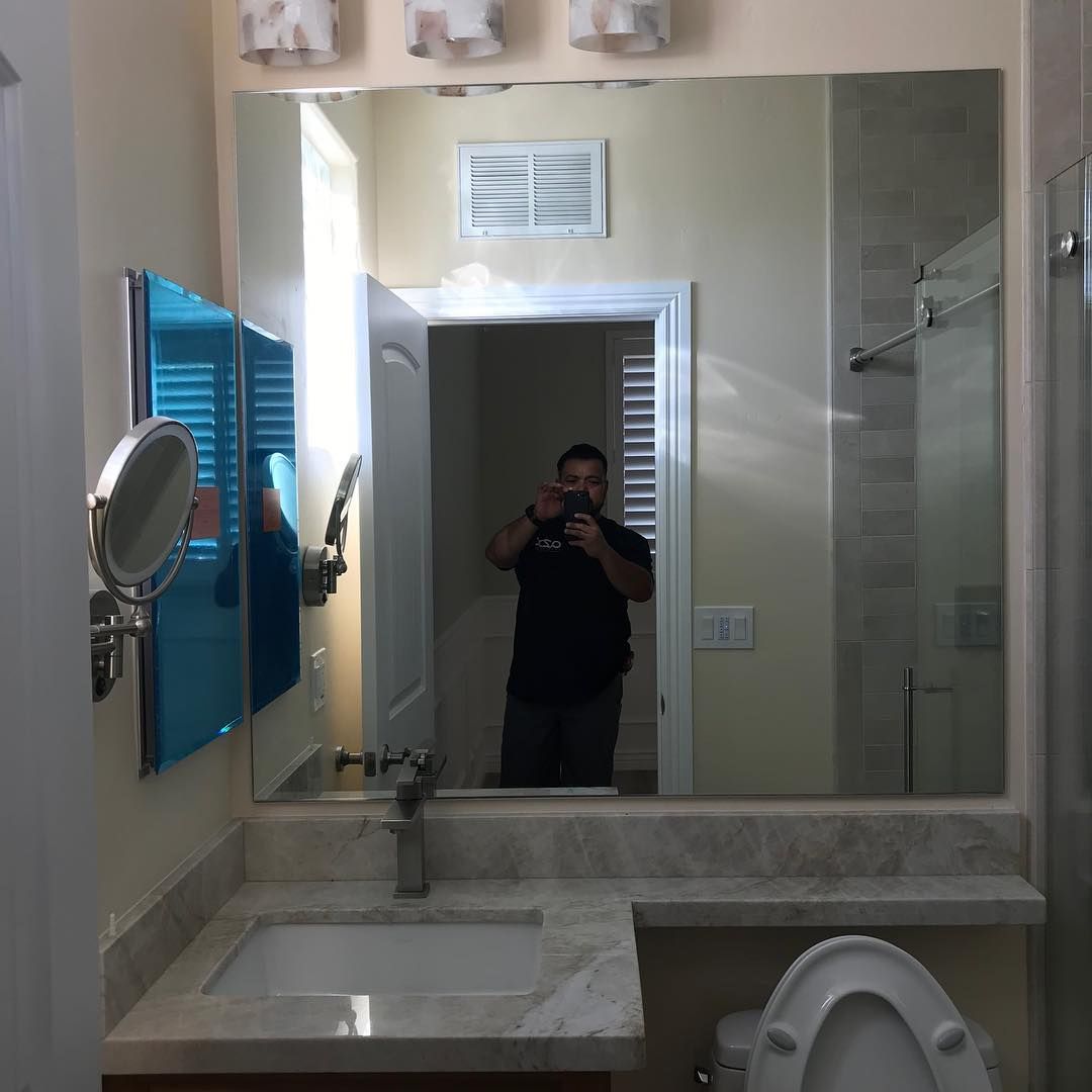A man is taking a picture of himself in a bathroom mirror