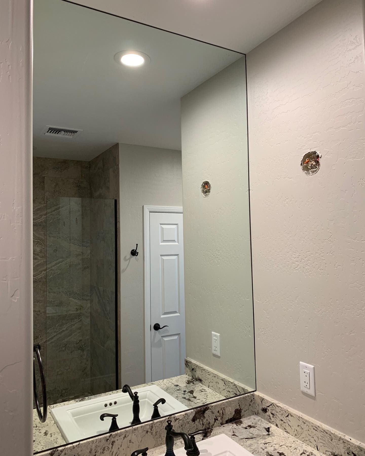 A bathroom with a sink and a large mirror.
