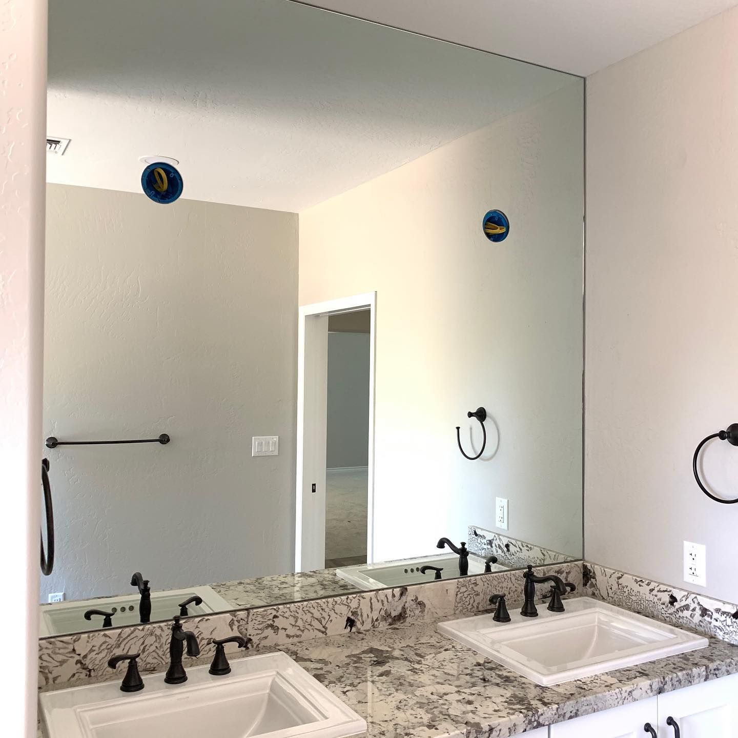 A bathroom with two sinks and a large mirror.