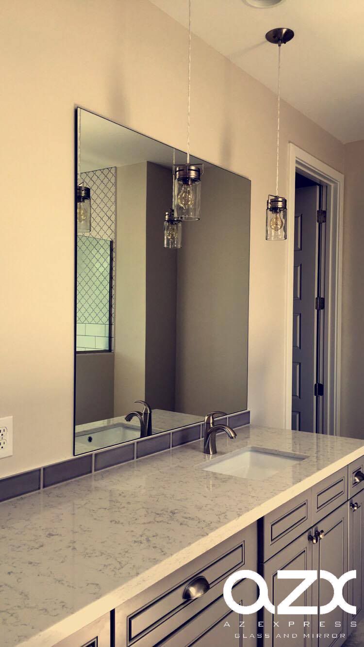A bathroom with a large mirror and a sink.