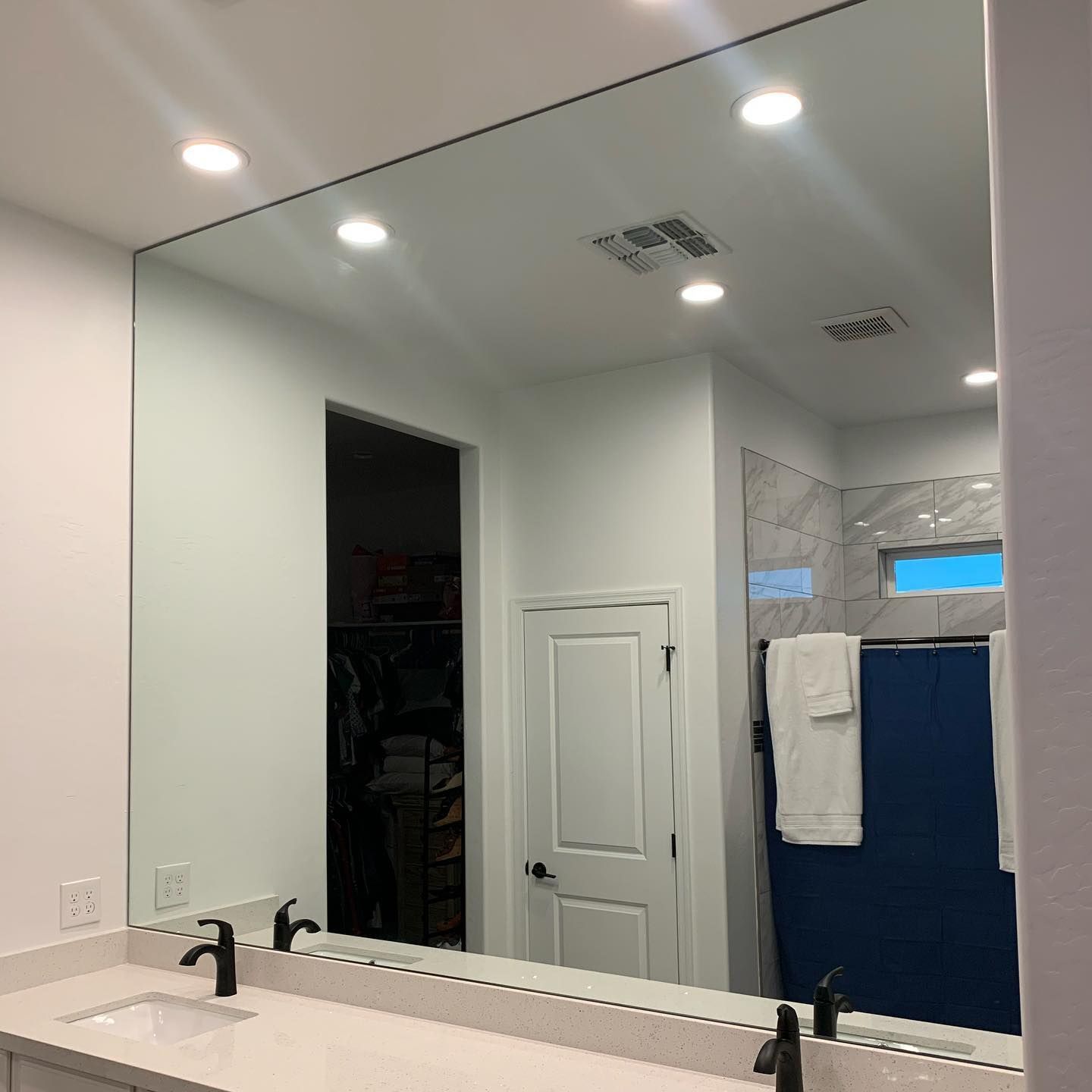 A bathroom with a large mirror and a sink.