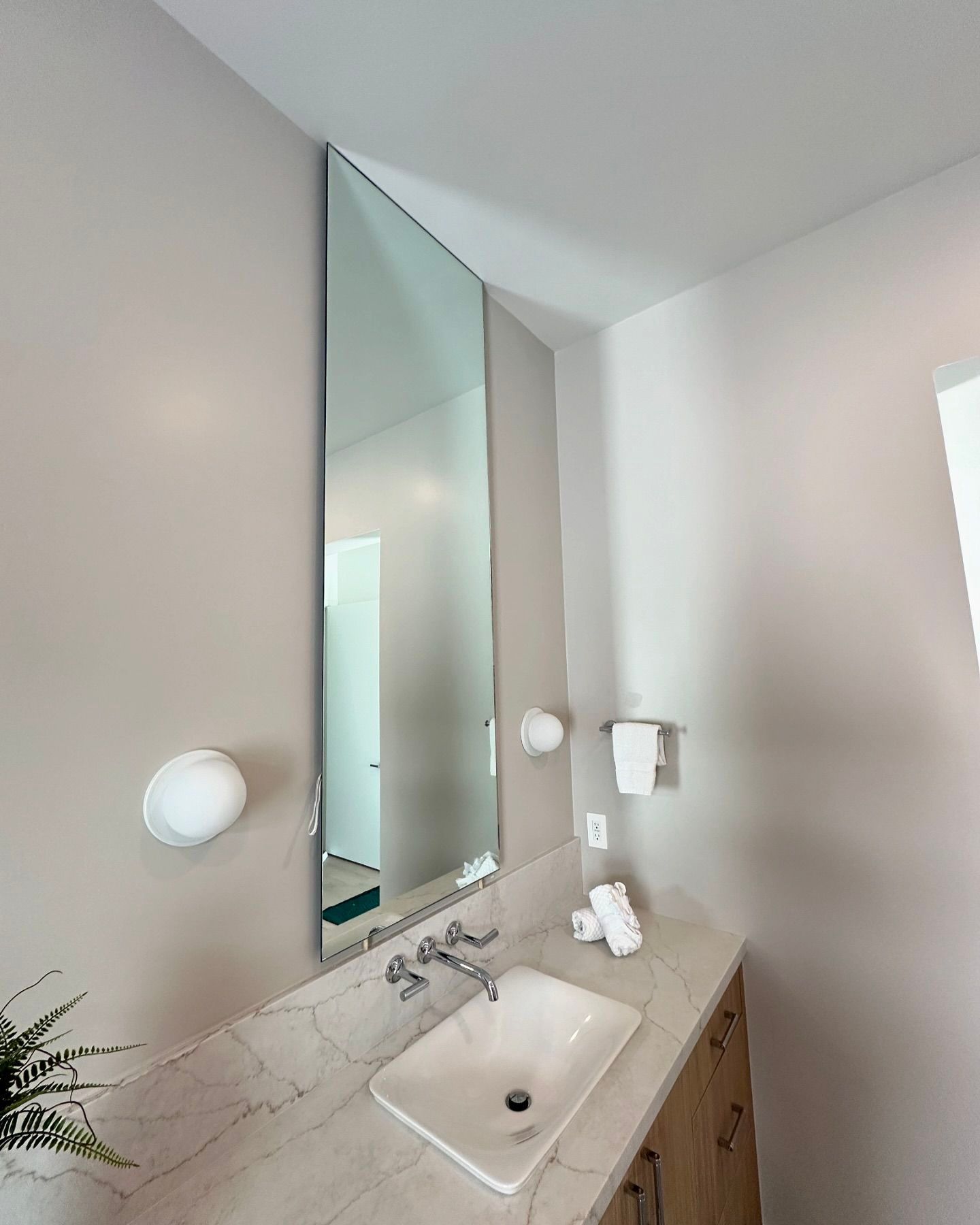 A bathroom with a sink and a large mirror