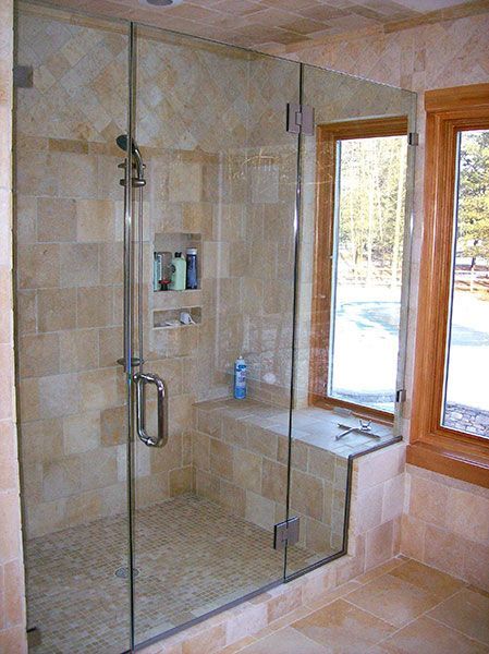 A bathroom with a walk in shower and a window