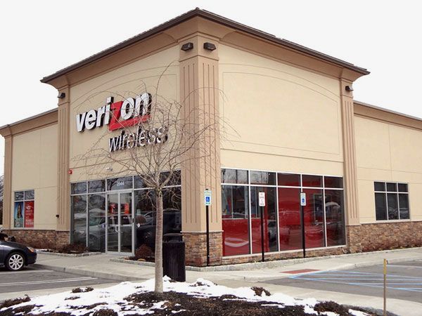 A verizon wireless store with a car parked in front of it
