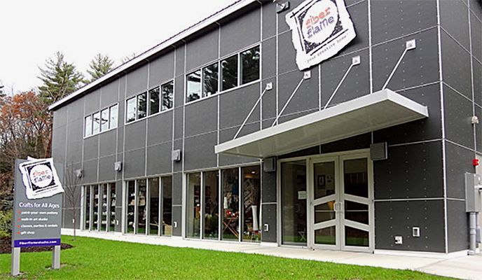 A large black building with a lot of windows and a sign in front of it.