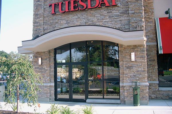 The front of a tuesday restaurant with a red awning
