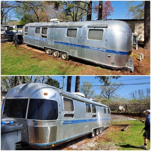 A silver airstream trailer is parked in a grassy field.