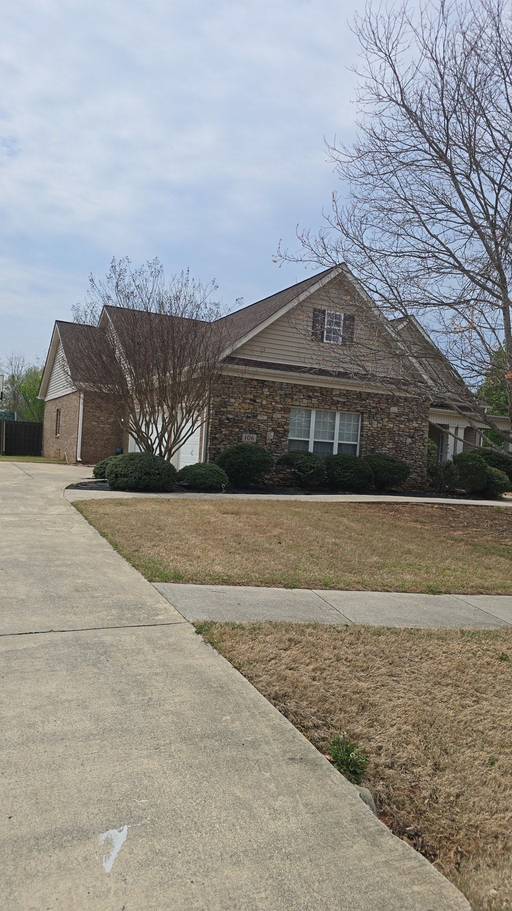 A house with a driveway and a sidewalk in front of it.