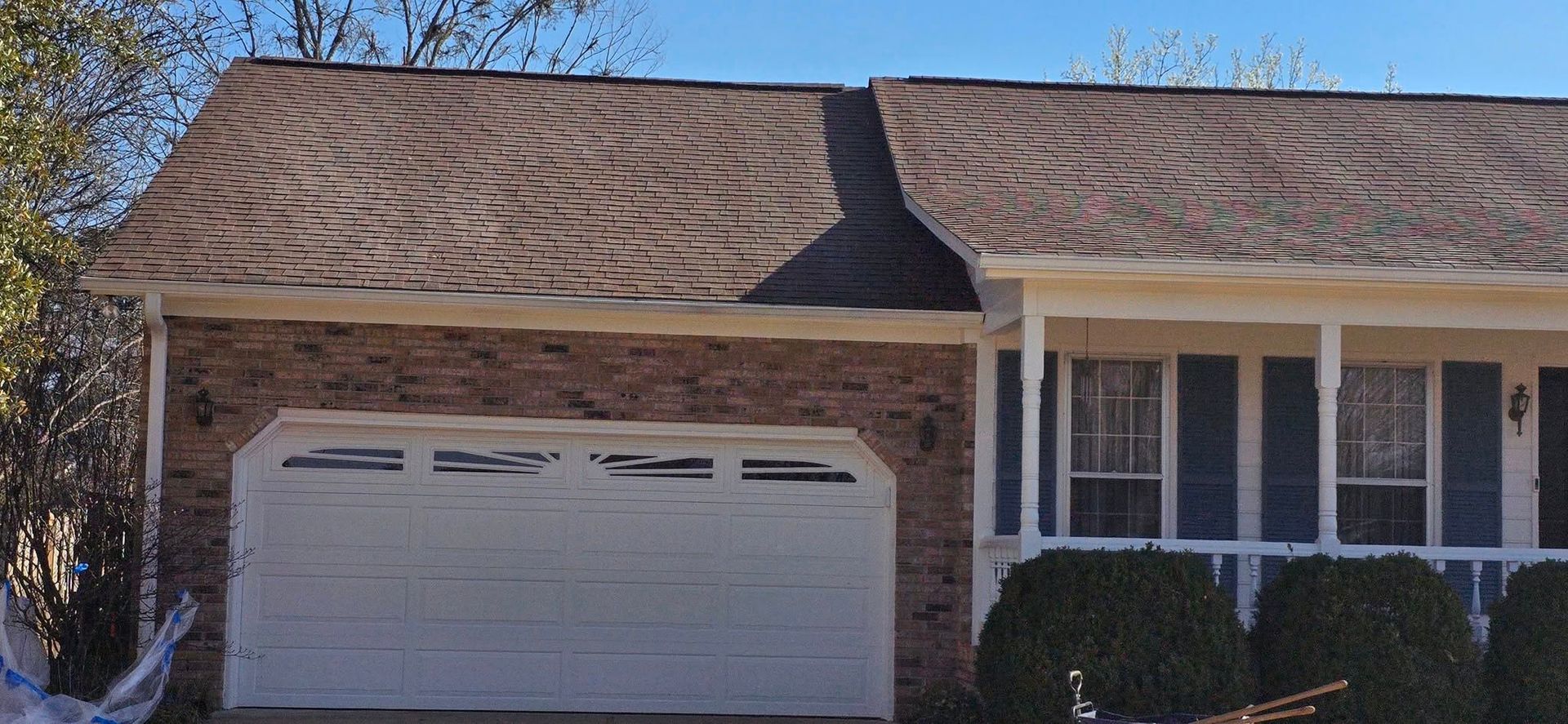 A house with a brown roof and a white garage door.