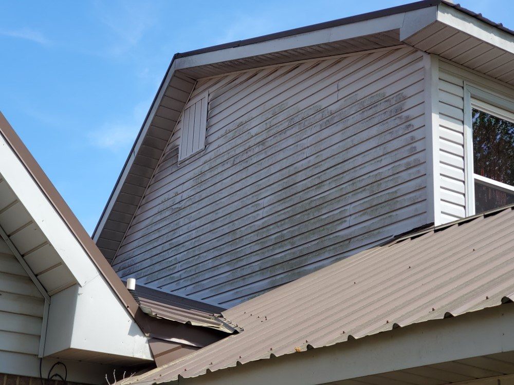 A house with a brown roof and a white siding