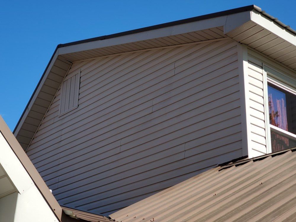A white house with a brown roof and a window