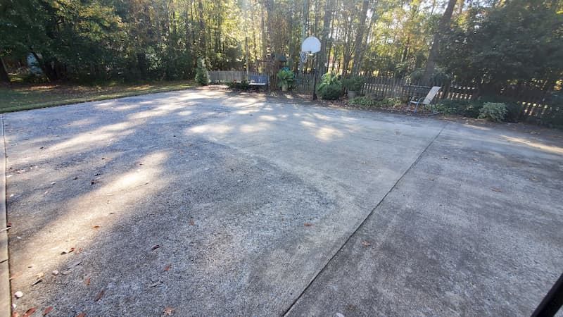 There is a basketball hoop in the middle of the driveway.