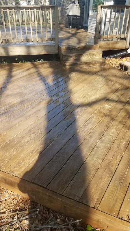 A wooden deck with a shadow of a person on it.