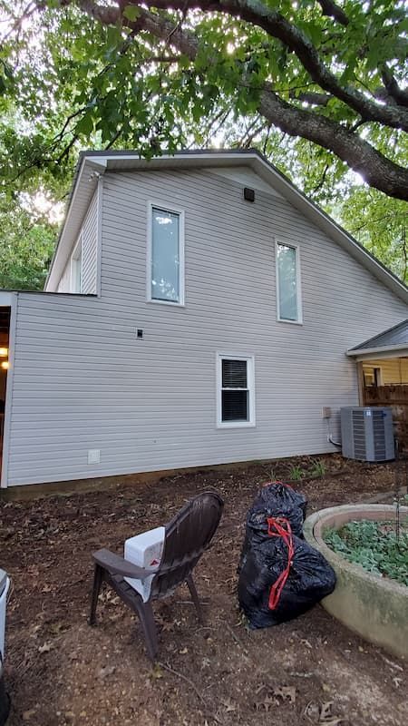 A house with a lot of windows and a chair in front of it.