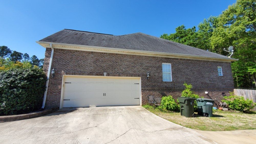 A large brick house with a garage and a driveway.