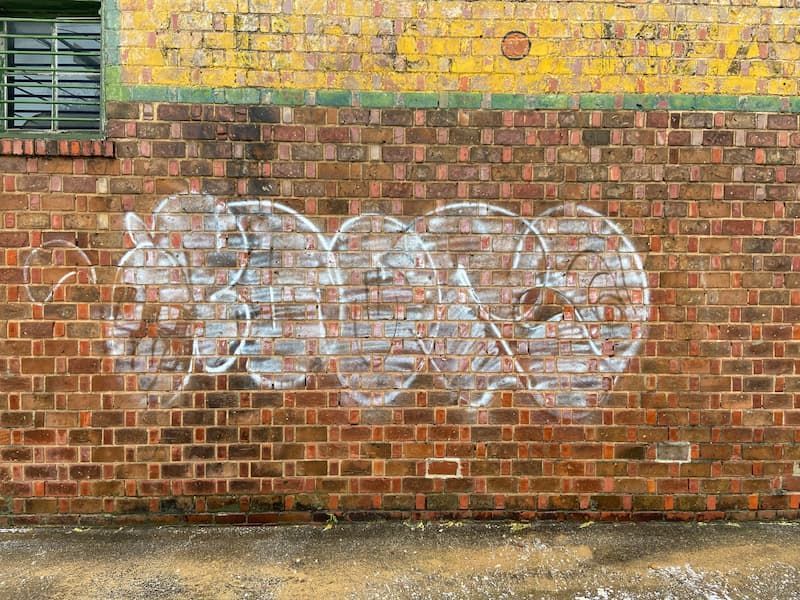 A brick wall with white graffiti on it