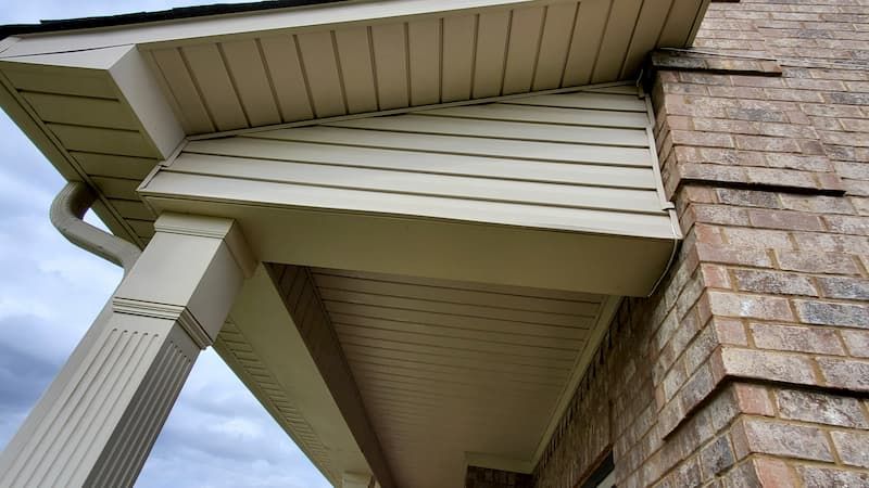 A brick building with a porch and gutter on it.