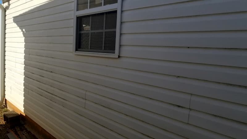 A white house with a window on the side of it.