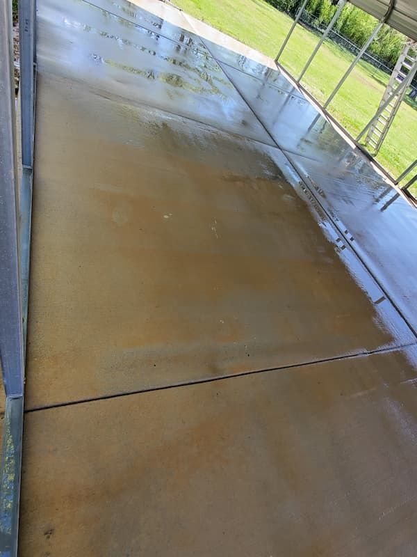 A concrete walkway with a reflection of a field in it.