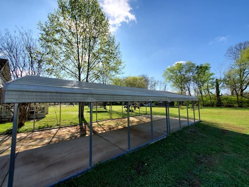 A carport in the middle of a grassy field