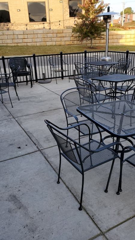 A patio with tables and chairs in front of a building.