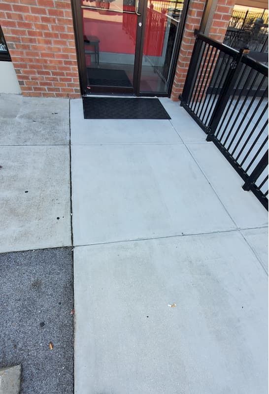 A brick building with a concrete walkway leading to it