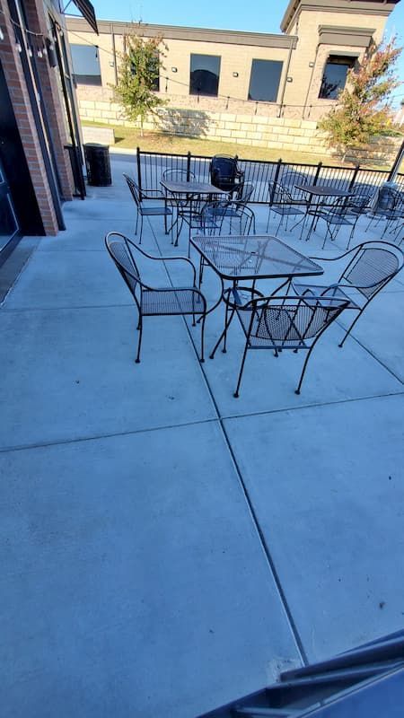 A patio with tables and chairs in front of a building.