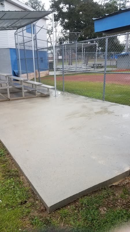 There is a concrete platform in the middle of a baseball field.