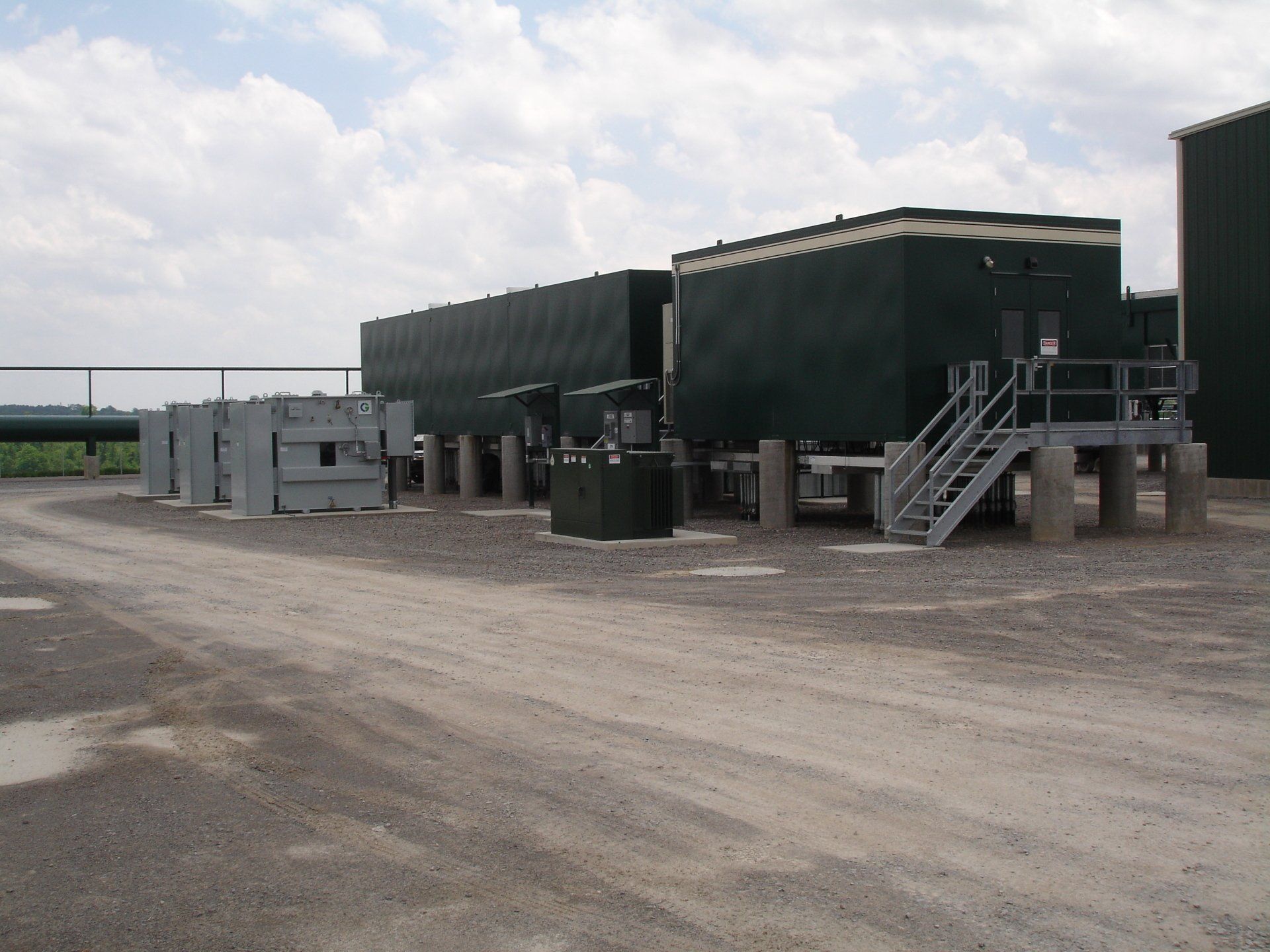 A large green building with stairs leading up to it