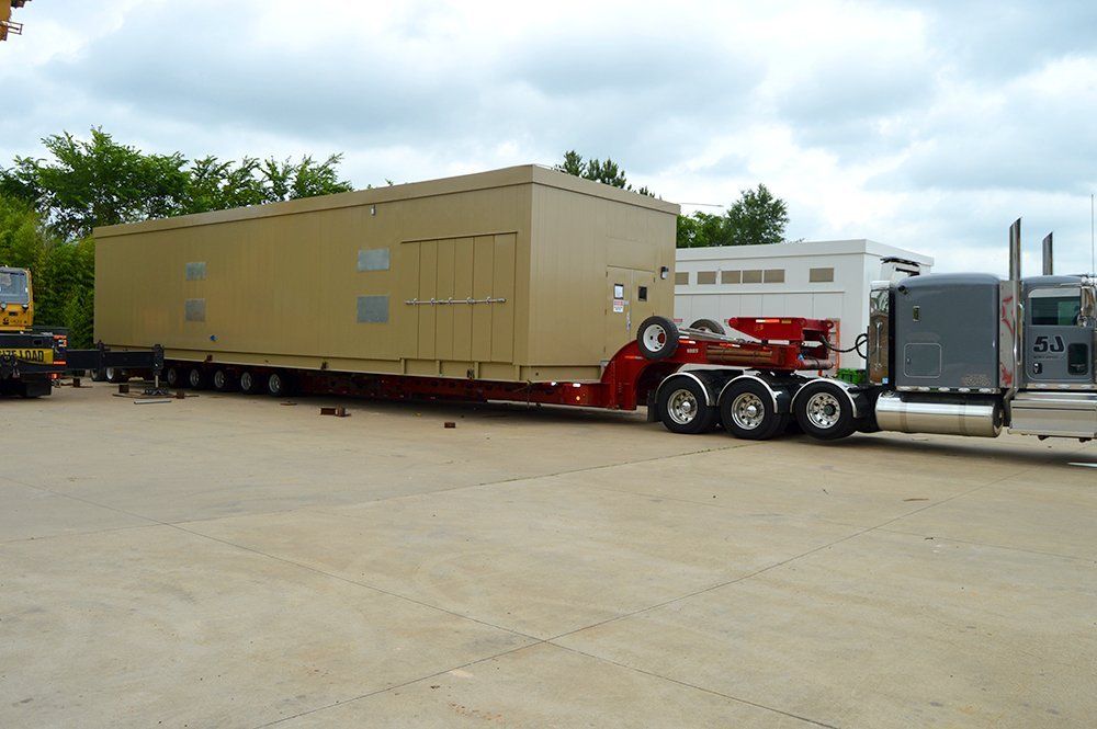 A semi truck is carrying a large container on a trailer