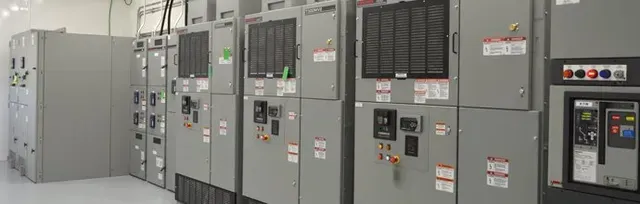 A row of electrical cabinets are lined up in a room.