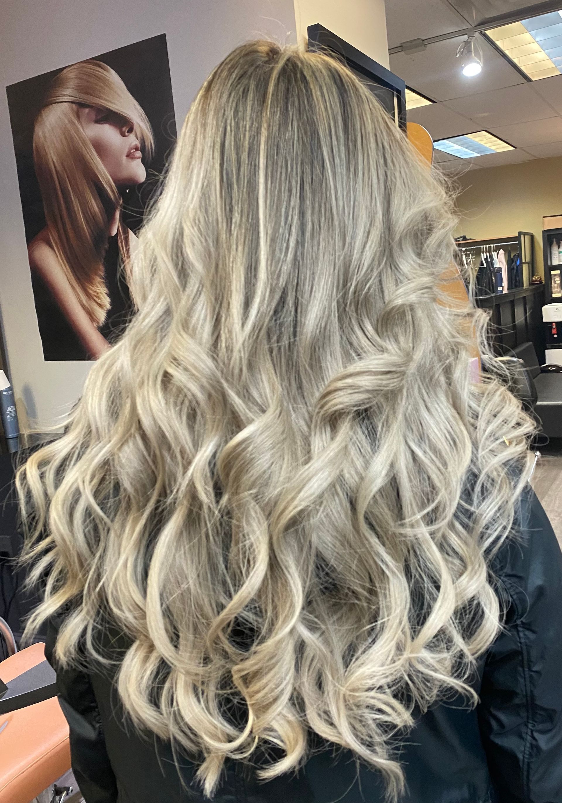 Long, wavy blonde hair in a salon setting.