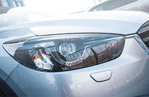 A close up of the headlight of a silver car