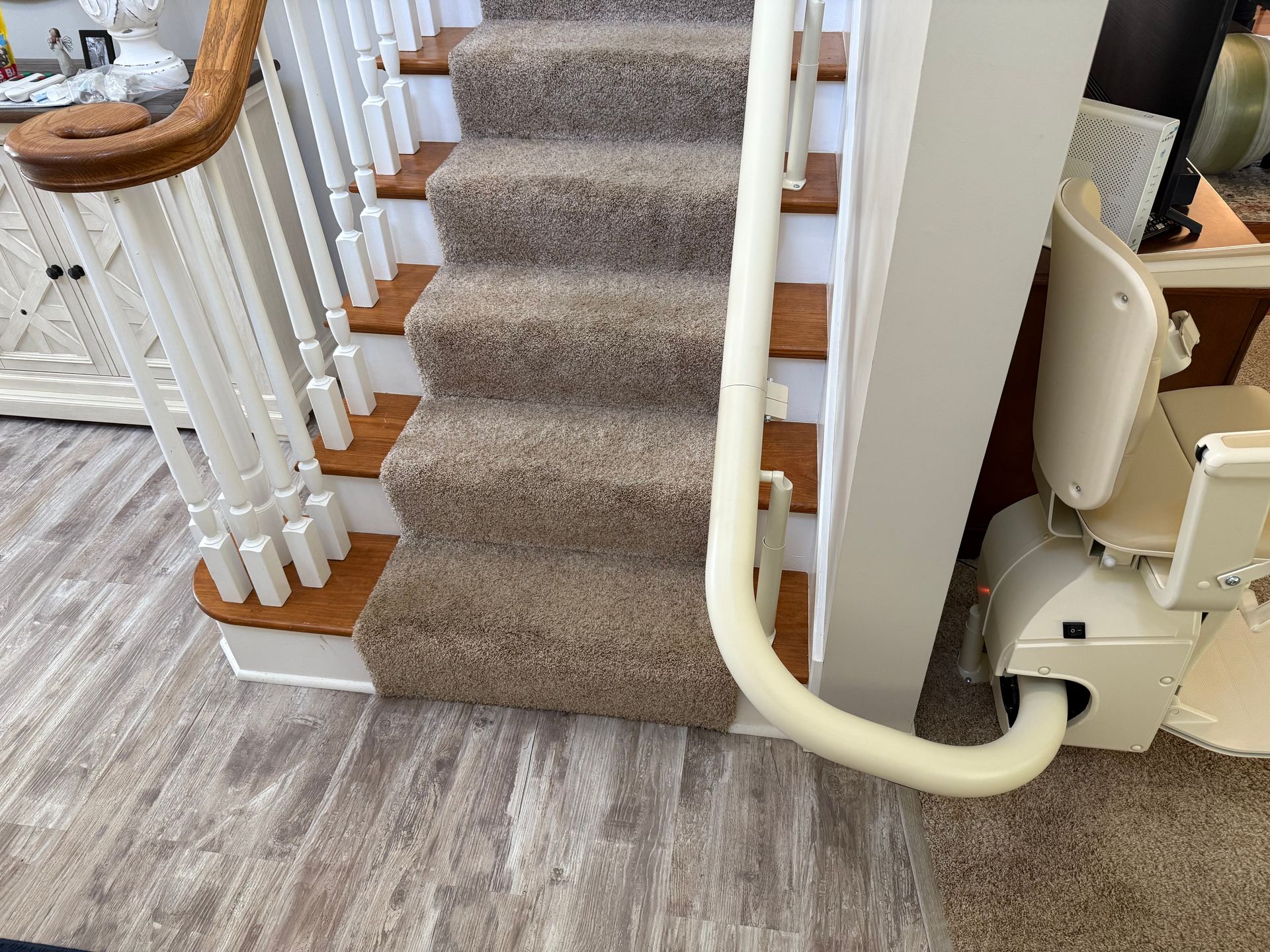 A stair lift is attached to the side of a staircase.