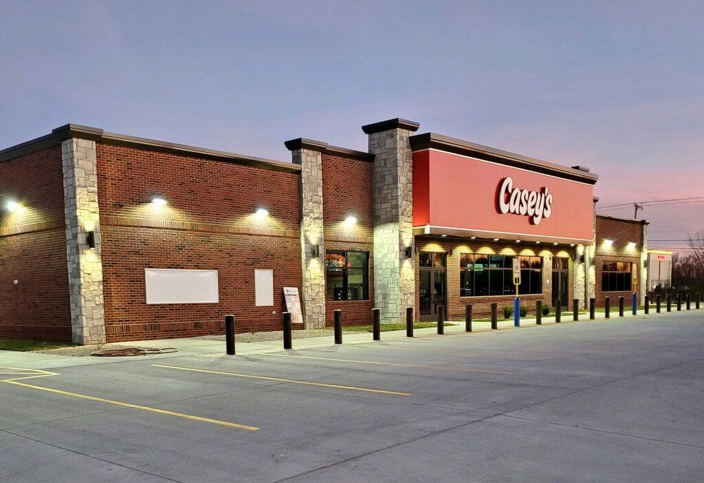 Exterior of Carey's Restaurant, a brick building with a red sign, at dusk. Parking lot in front.