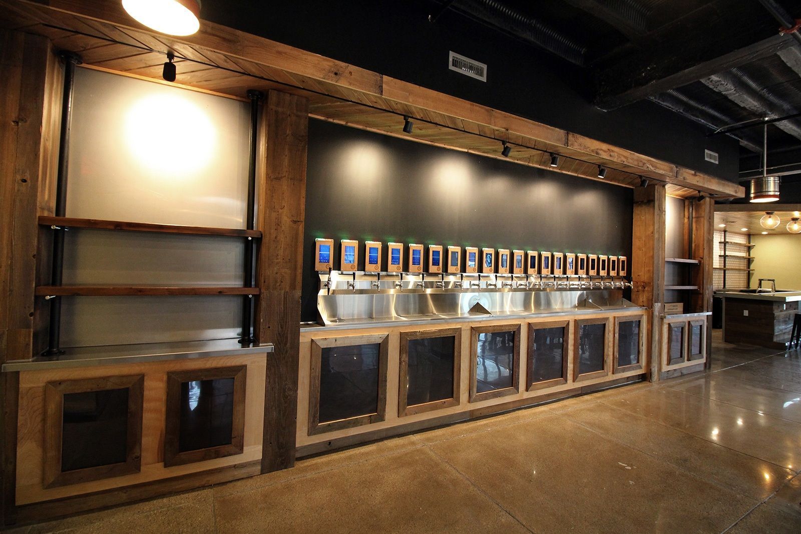 Bar with beer taps, wooden accents, and concrete floor.