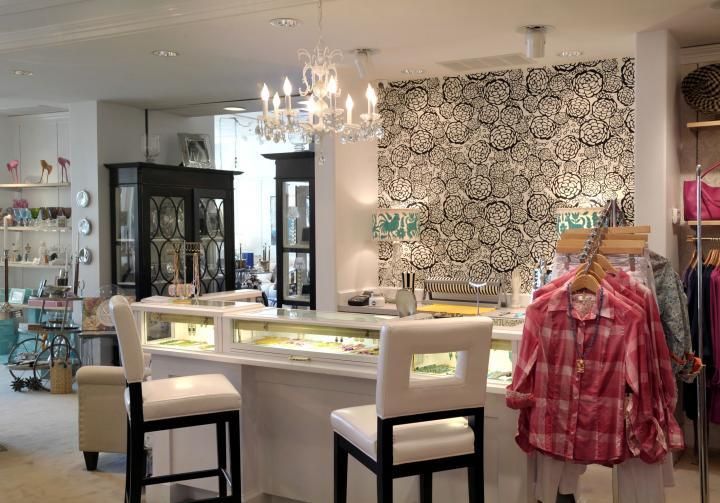 Jewelry store interior with a display counter, chairs, and decorative wallpaper.