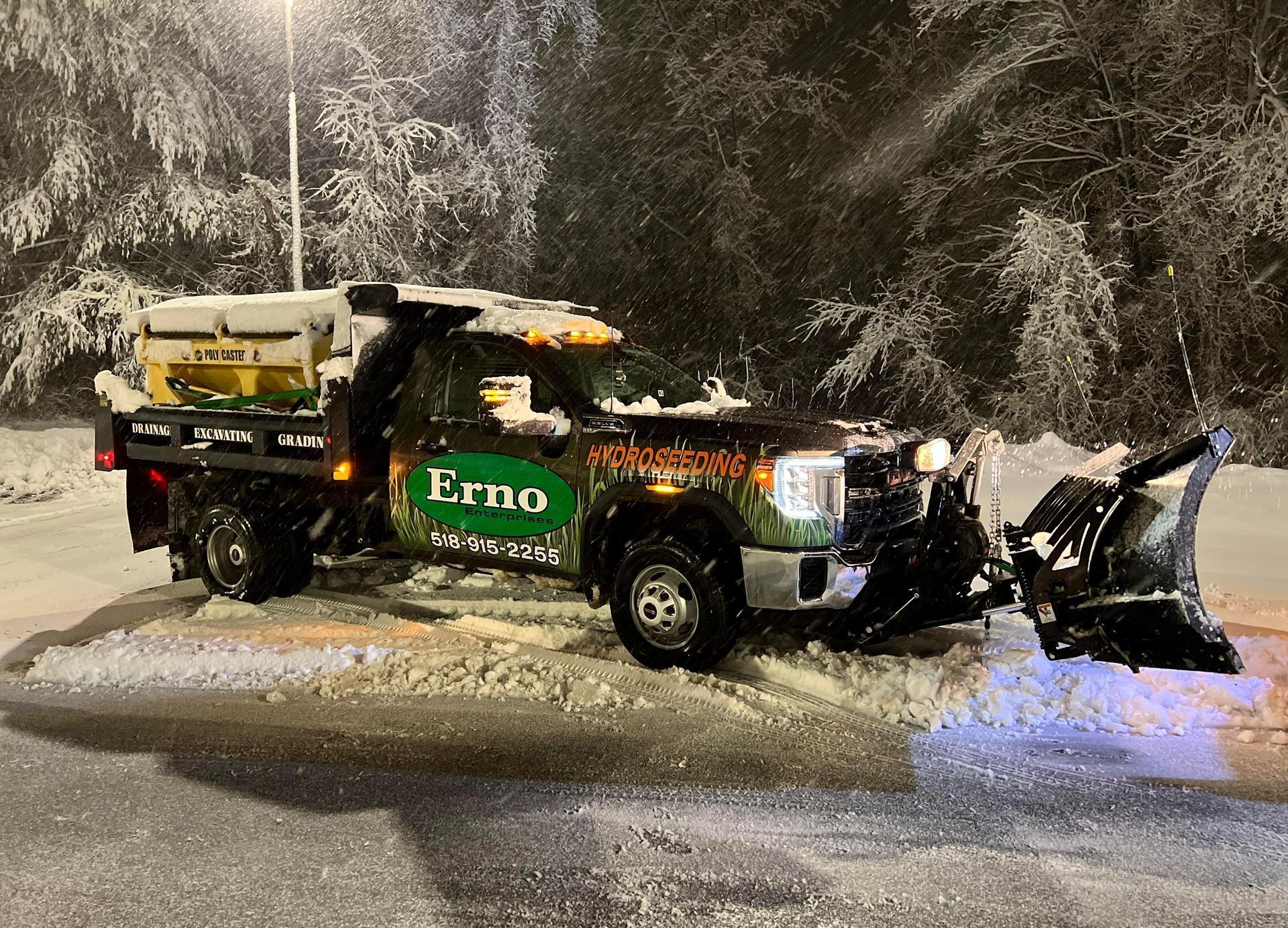a snow plow is sitting on the side of the road at night