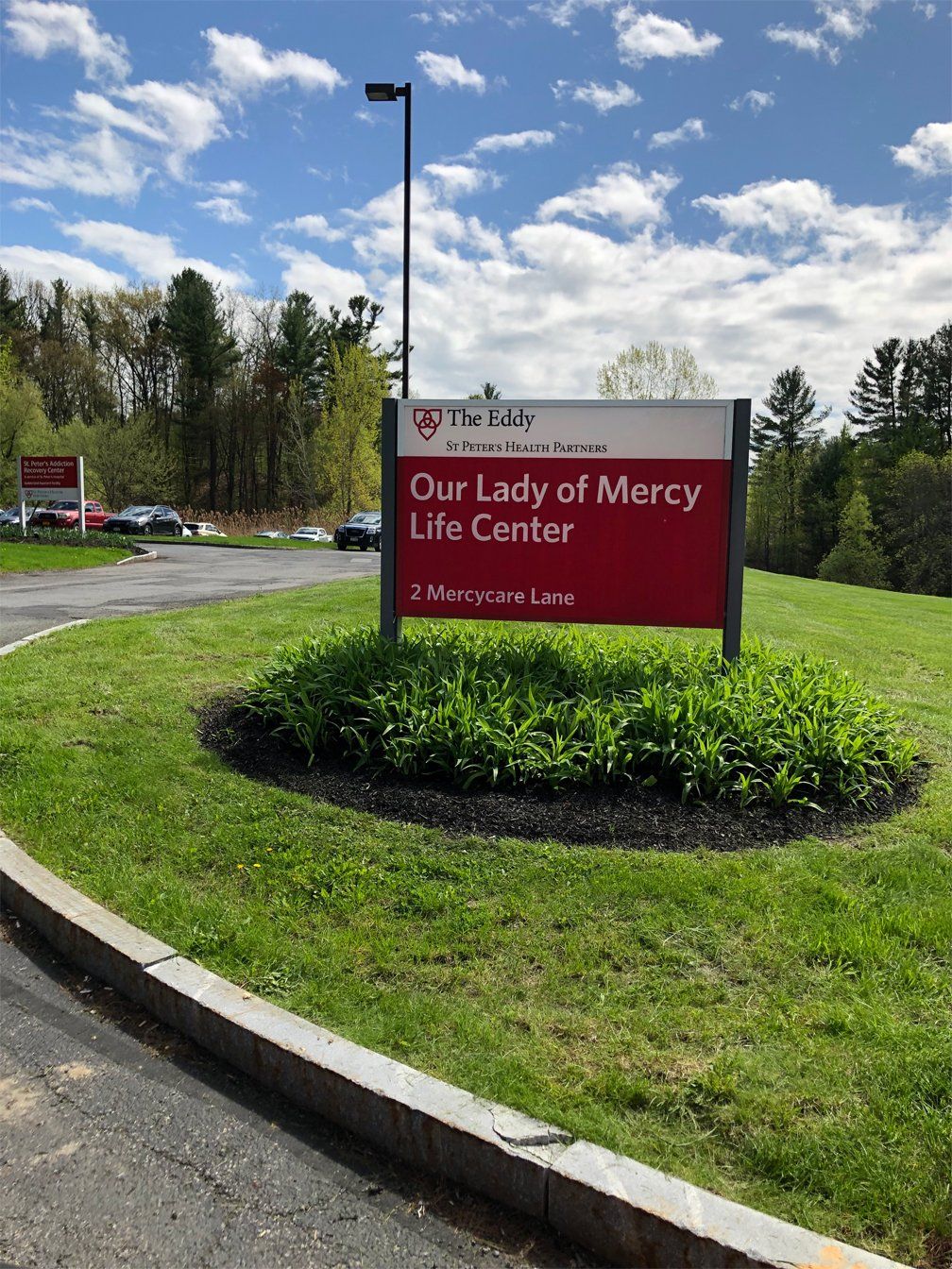Commercial landscaping with signage at entrance.