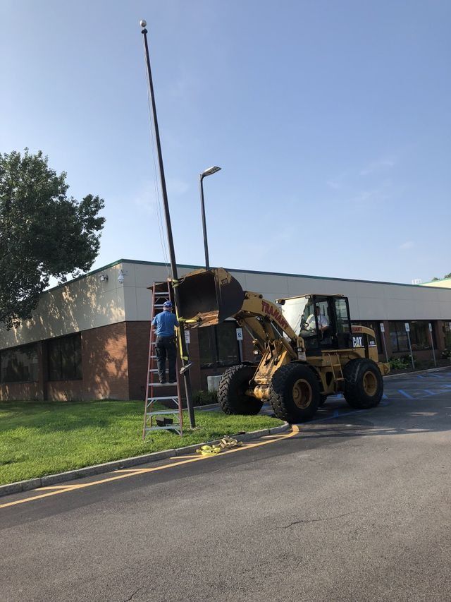 a man is standing on a ladder next to a bulldozer in front of a building