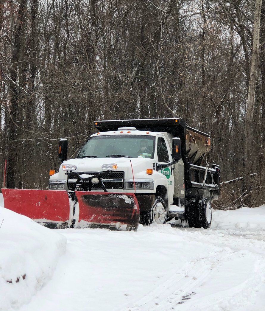 a snow plow is moving snow in a parking lot