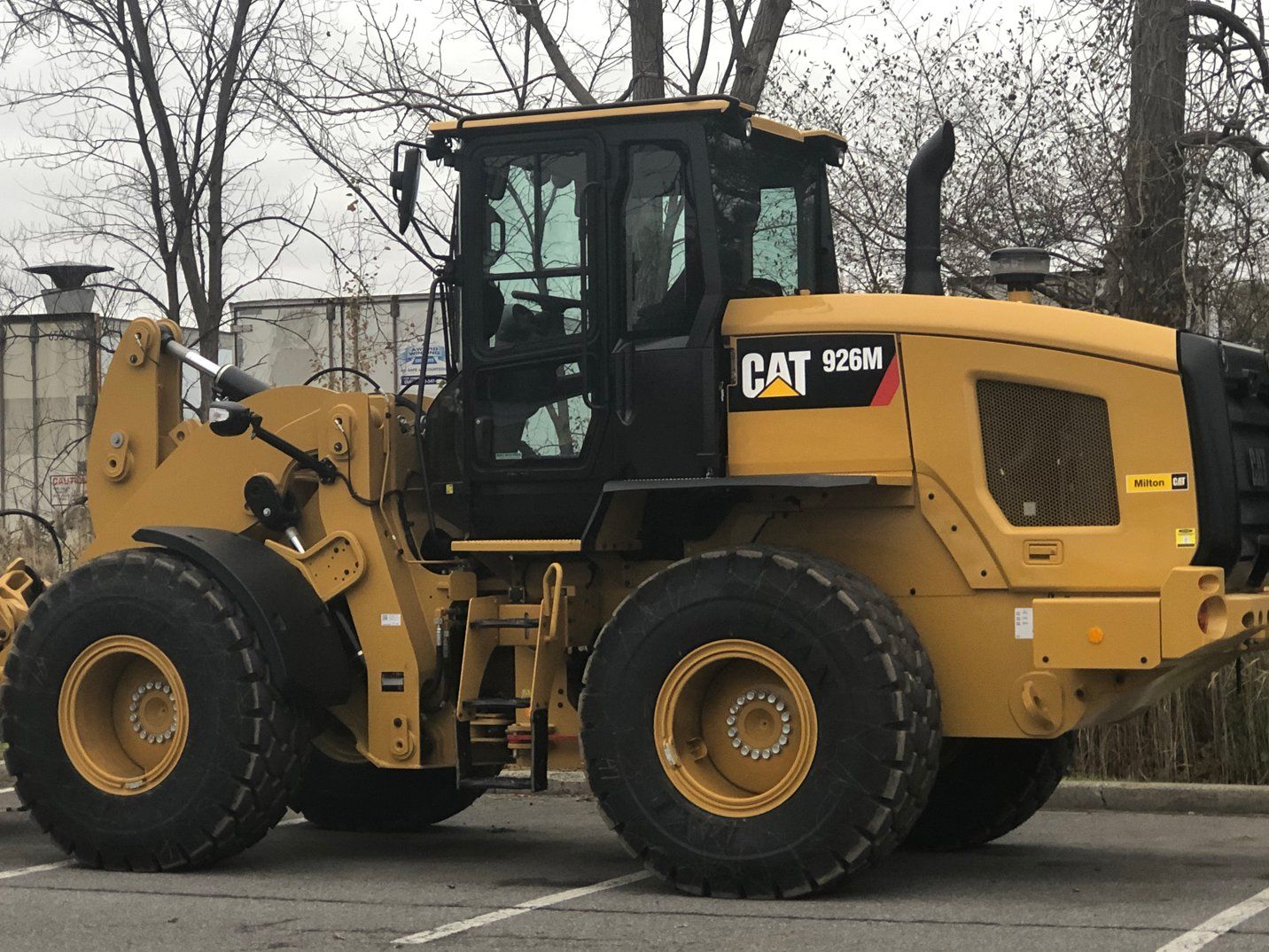 a cat wheel loader is parked in a parking lot .