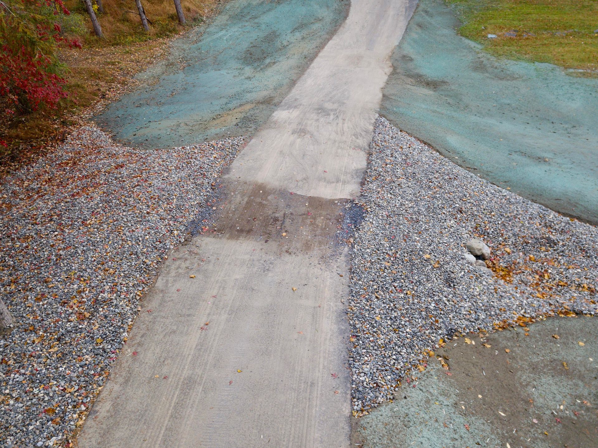 an aerial view of a dirt road surrounded by gravel and hydroseeding .