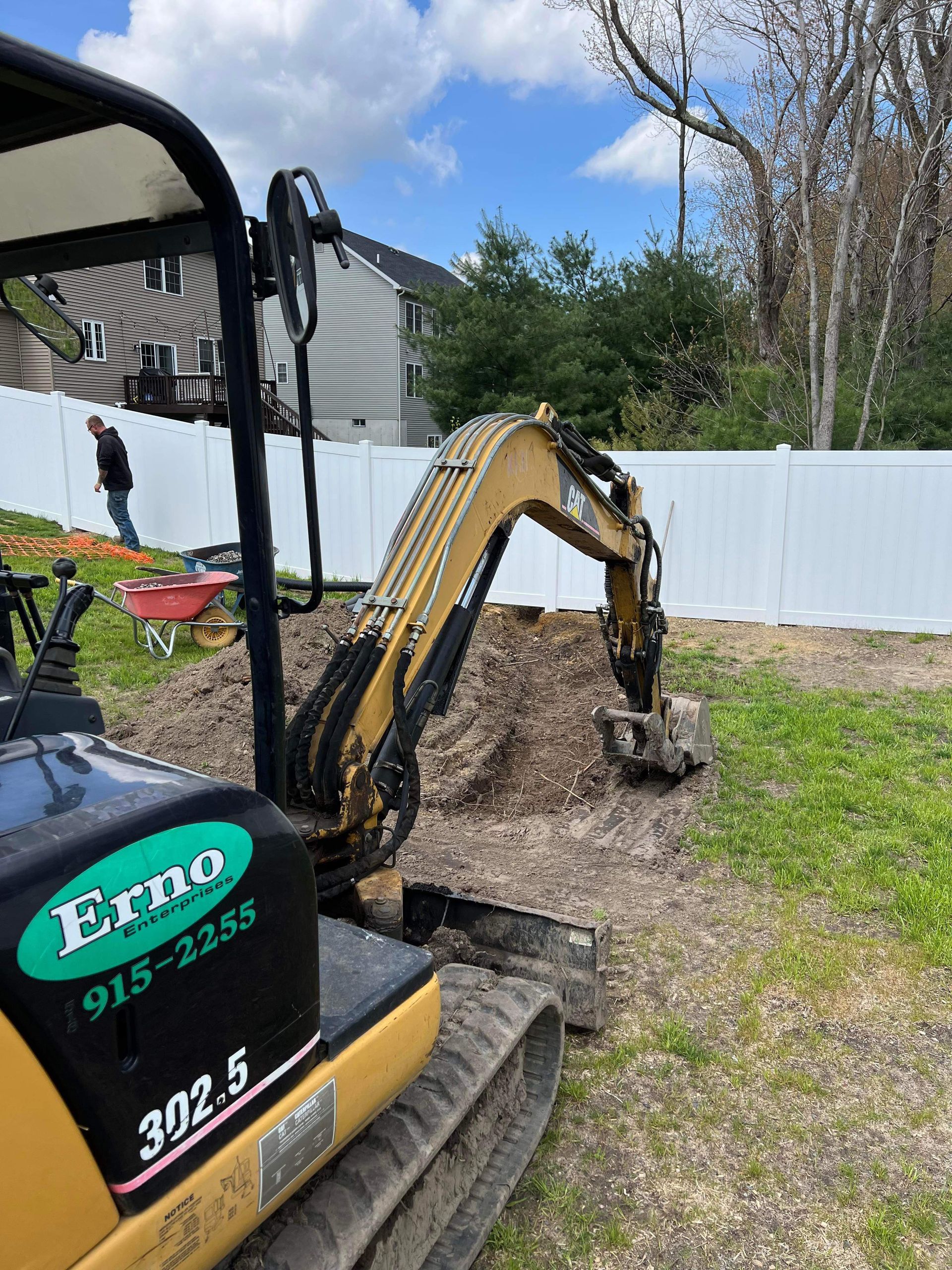 a small excavator is digging a hole in a yard .
